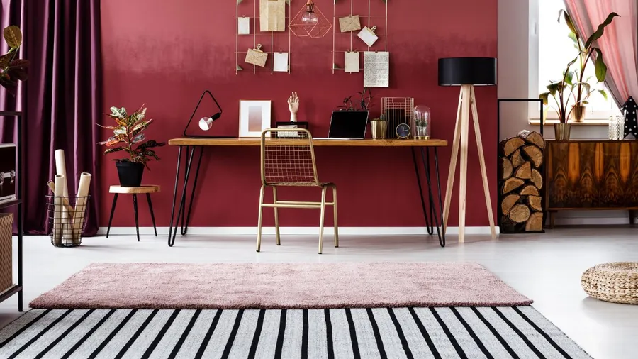 Modern workspace with deep burgundy accent wall and minimalist decor.