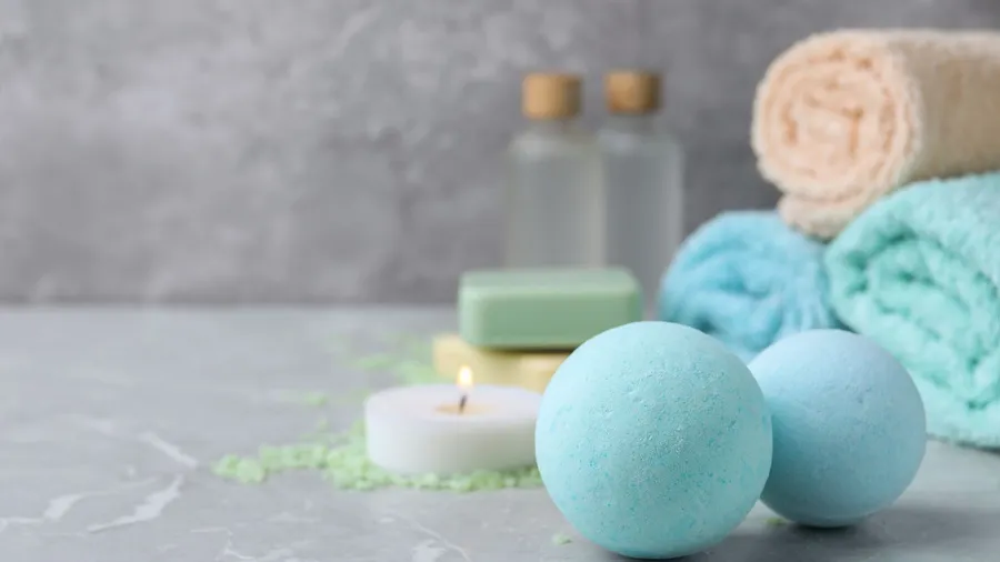 Spa or bath items including candles, towels, and bottles.
