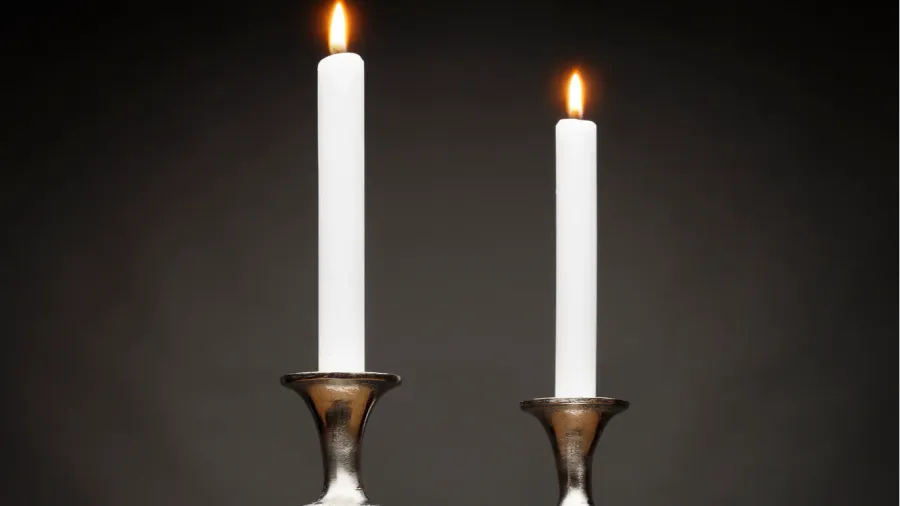 2 tall silver candle holders and glowing candles shot on