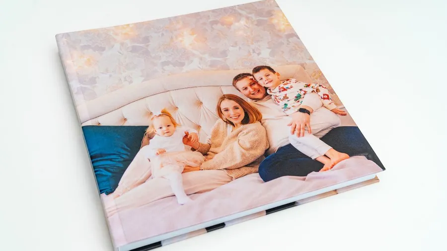 A personalized photo album of a family on a bed.