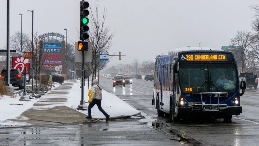 Man getting of the bus during winter storm on Touhy Ave in Niles, Illinois, United States.