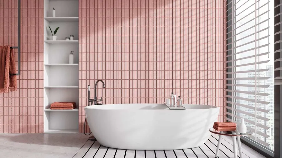 A big white bathtub by the window and a table in a pink bathroom