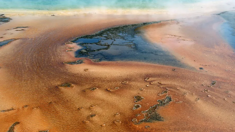 A striking aerial view of Yellowstone’s lava layers in Wyoming, showcasing rugged volcanic formations.