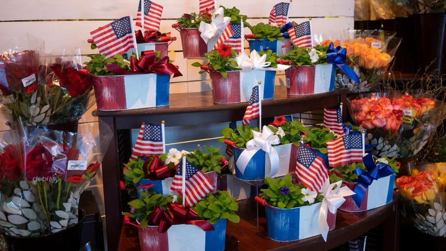 Planters painted in red, white, and blue with mini USA flags in them.