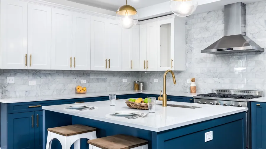 Beautifull kitchen with blue and white cabinetry, gold accents and marble backsplashs. Elegant Kitchen 1784492141