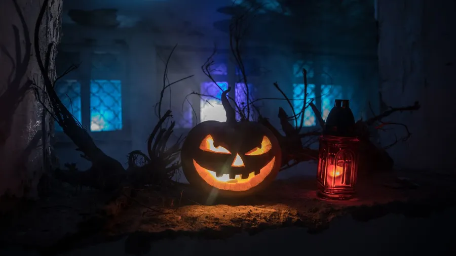 Scary Halloween pumpkin in the mystical house window at night or halloween pumpkin in night on abandoned room with window.