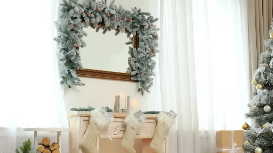 A cozy living room interior with a decorative mirror with garland above the fireplace.