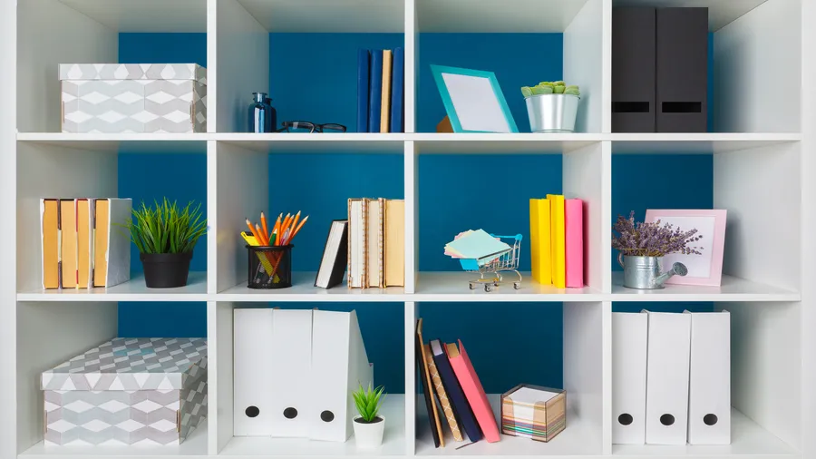 Wooden built-in shelves with books, decorative storage boxes, and decor accents.