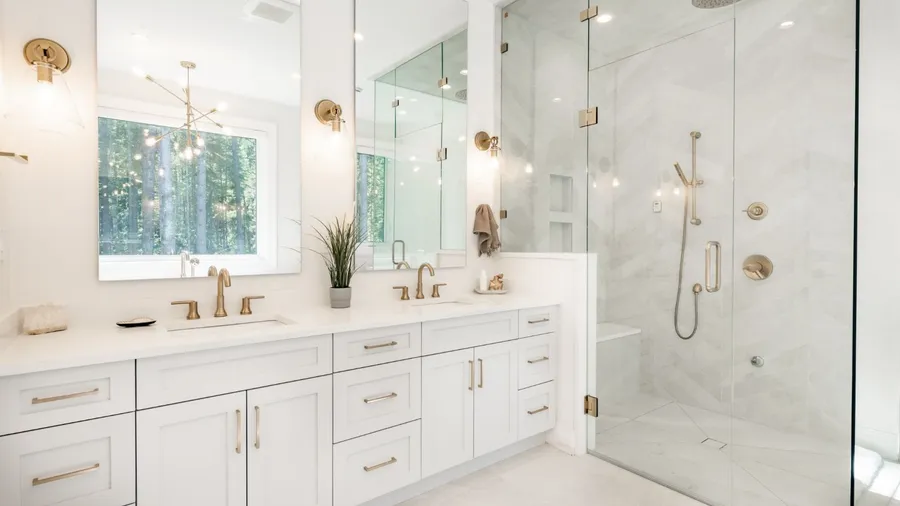 A modern bathroom with dual sinks, a large mirror, and a glass shower.