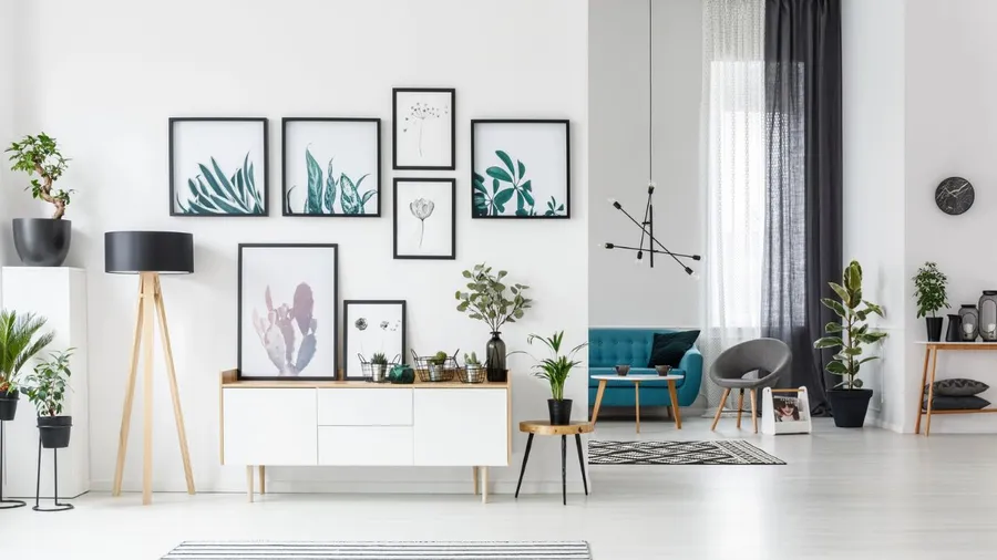A stylish hallway with a gallery wall of framed artwork, potted plants, and modern furniture.