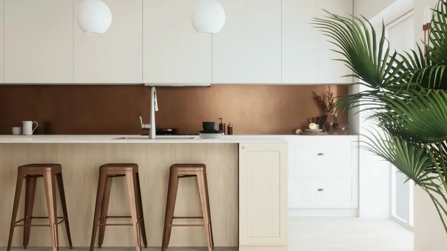 Bright kitchen with white cabinets, copper backsplash, and a large plant.