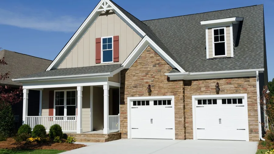 A house with a brick and siding exterior, featuring a double garage.