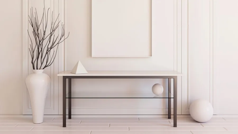 A minimalist space with a white table, vase, and geometric decor.