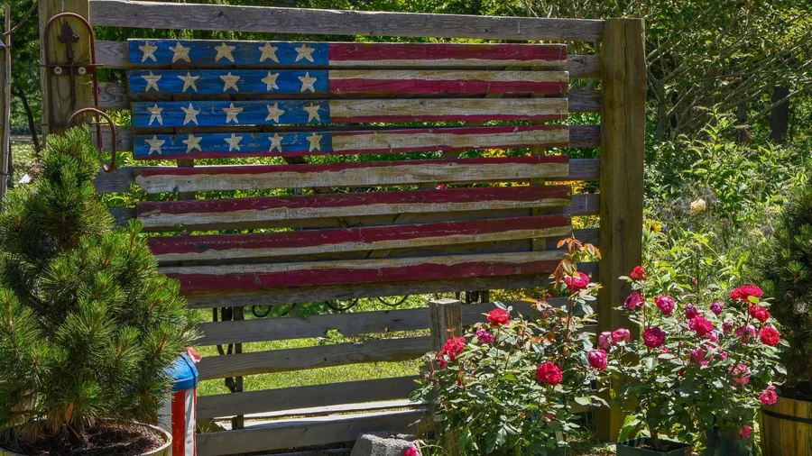 A USA flag painted on a wooden fence.