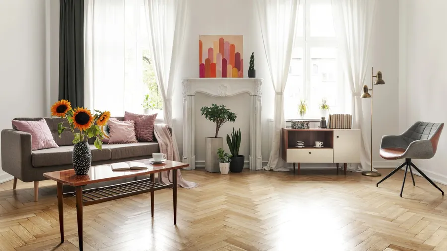 Cozy living room with white sofas, large windows, and modern decor.
