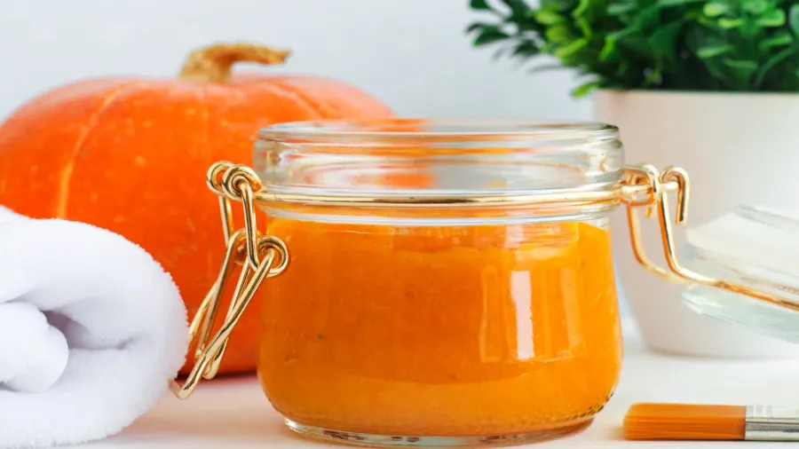 Homemade pumpkin face mask in a glass jar. DIY cosmetics and spa recipe. Copy space.