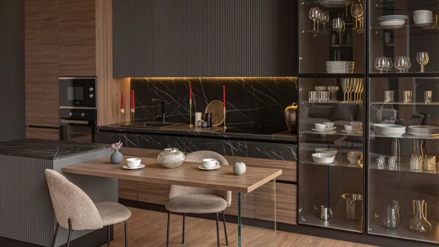 Modern kitchen with dark cabinetry and a marble backsplash, decorated with red candles.