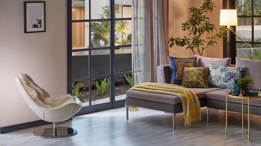 Modern living room with colorful cushions and large window.