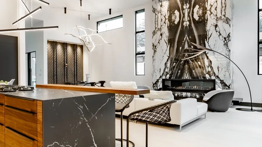 A modern living area featuring sleek furniture, a striking marble wall, and stylish lighting fixtures.