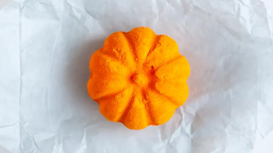 Scented orange bath bomb in the shape of a pumpkin. Skin care product.