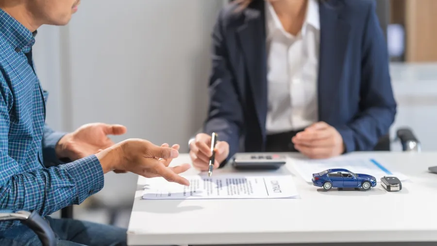 Asian businesswoman specializing in car loan services. Proficient in terms like extended warranty, lease, MSRP, and navigating financing options for customers' automotive needs.