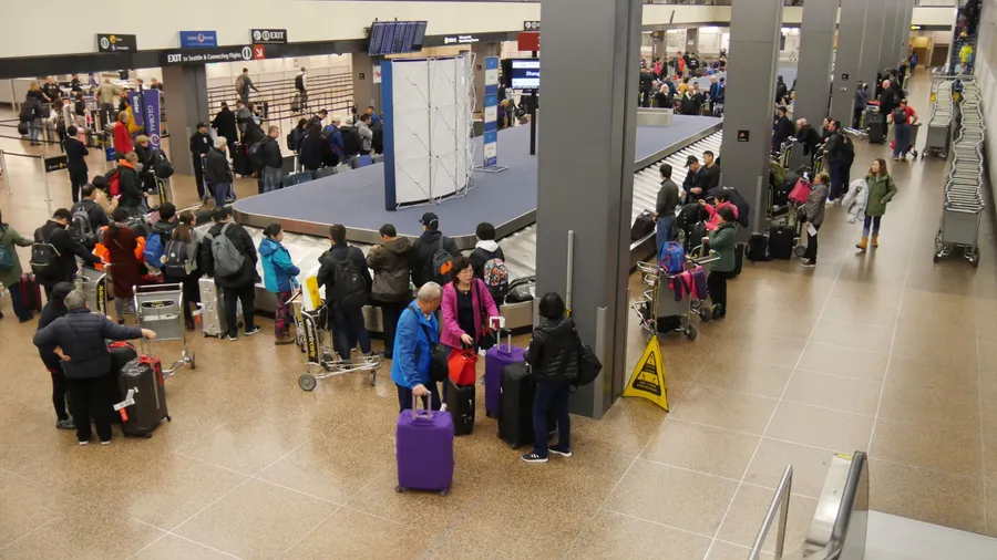 Passengers wait for their luggage at the baggage claim area at the Seattle-Tacoma International Airport.