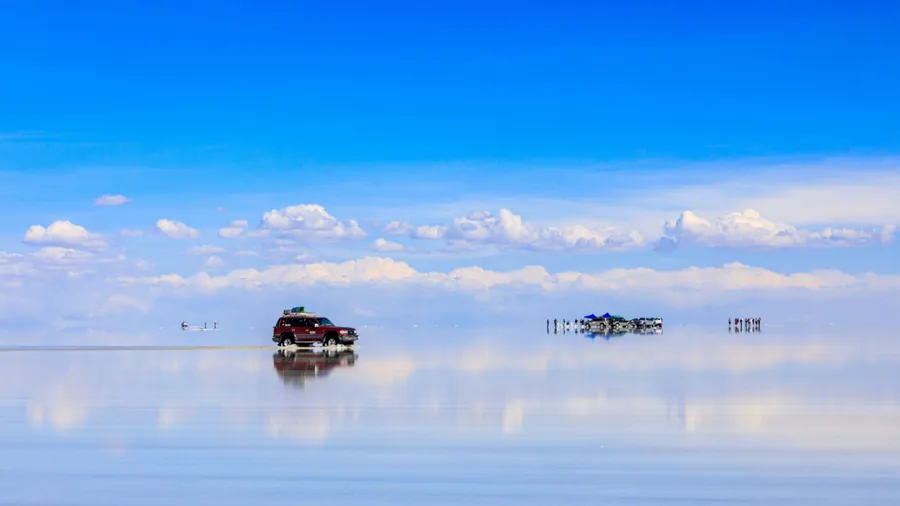 A breathtaking reflection of the sky in Bolivia's Salar de Uyuni Salt Flats, where shallow water reflects the sky like a mirror. This is the "sky mirror" phenomenon, where the sky and clouds are symme