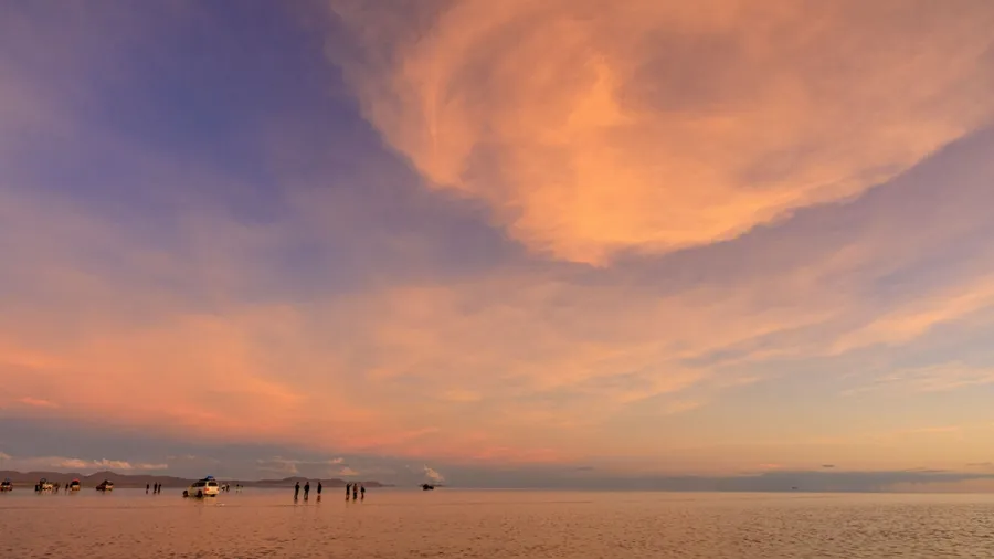 A breathtaking reflection of the sky in Bolivia's Salar de Uyuni Salt Flats, where shallow water reflects the sky like a mirror. This is the "sky mirror" phenomenon, where the sky and clouds are symme