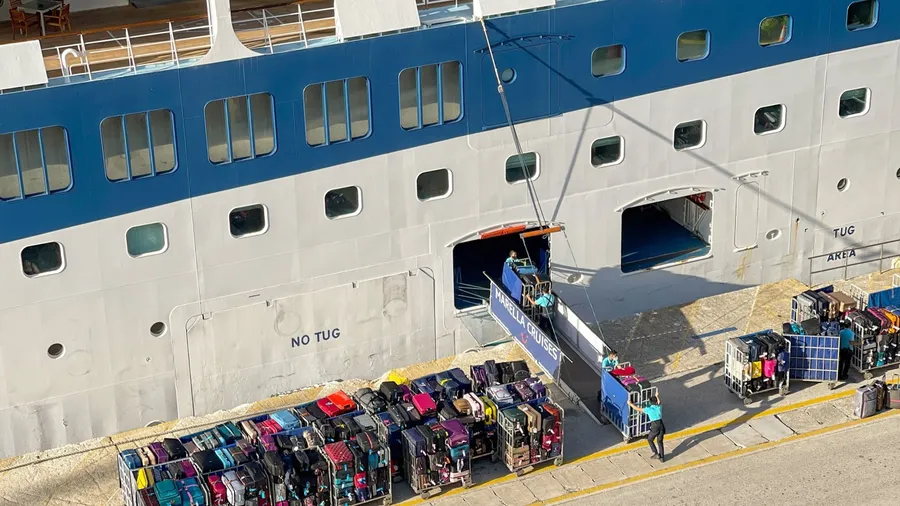 Athens, Greece - may 2022: Crew of a cruise ship unloading trolleys stacked with luggage at the end of a cruise