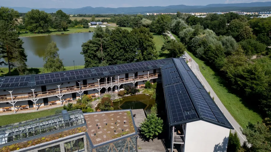 Aerial view of solar panels on a rooftop of hotel complex. Solar energy as renewable energy source in business.