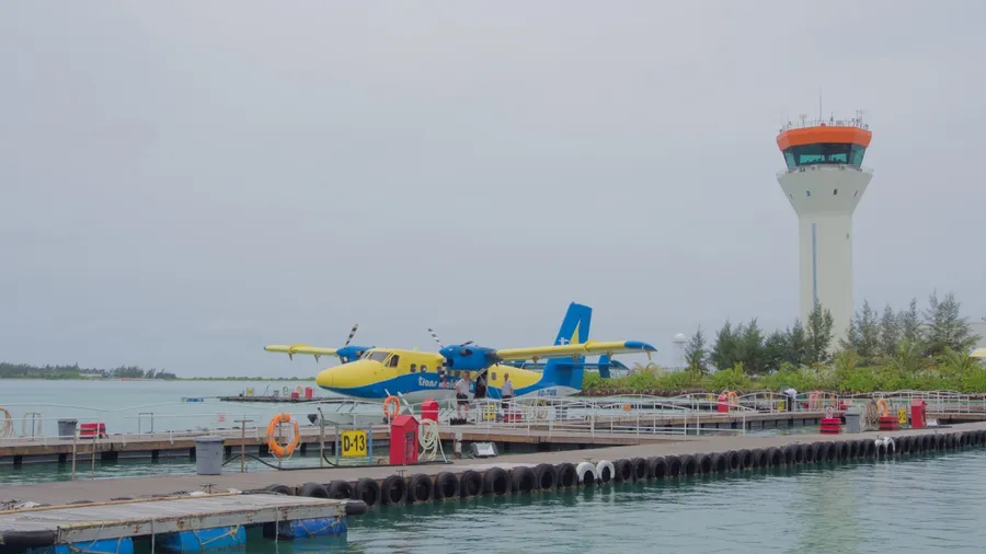 Velana International Airport (MLE), Aug 12, 2014: Trans Maldivian Airways seaplane is docked at the terminal pier with the white and orange Air Traffic Control (ATC).