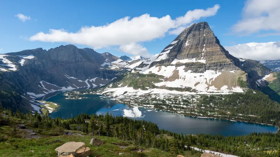 The scenic view of the lake and mountains in Glacier National Park on a sunny day