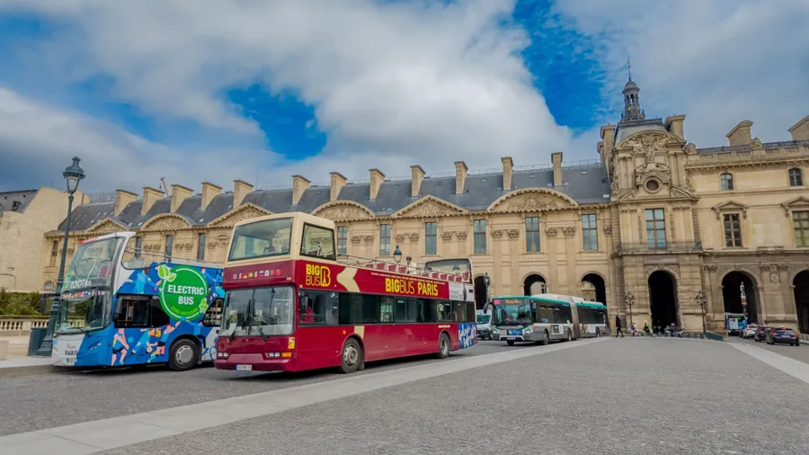 Tourist buses parked outside the historic architecture in Paris, France, capturing the essence of urban European travel on April 14th, 2024