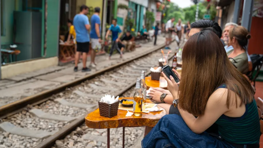 Railway cafe. People drink coffee waiting for train to arrive on railway road in Hanoi, Vietnam.