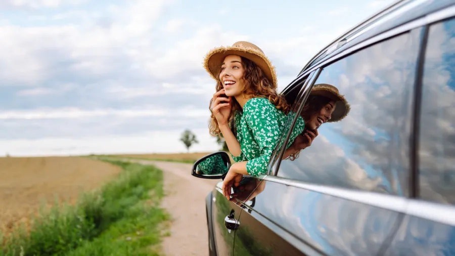 Woman tourist on road, enjoying window view and traveling on holiday road trip. Travel adventure drive.