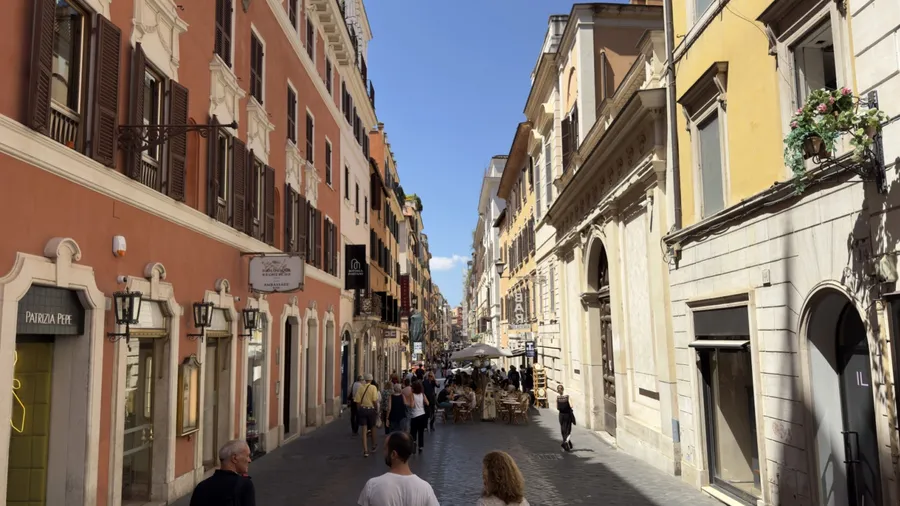 Crowded Via Frattina in Rome with historic façades and pedestrians in summer light. Italy 18.07.2025