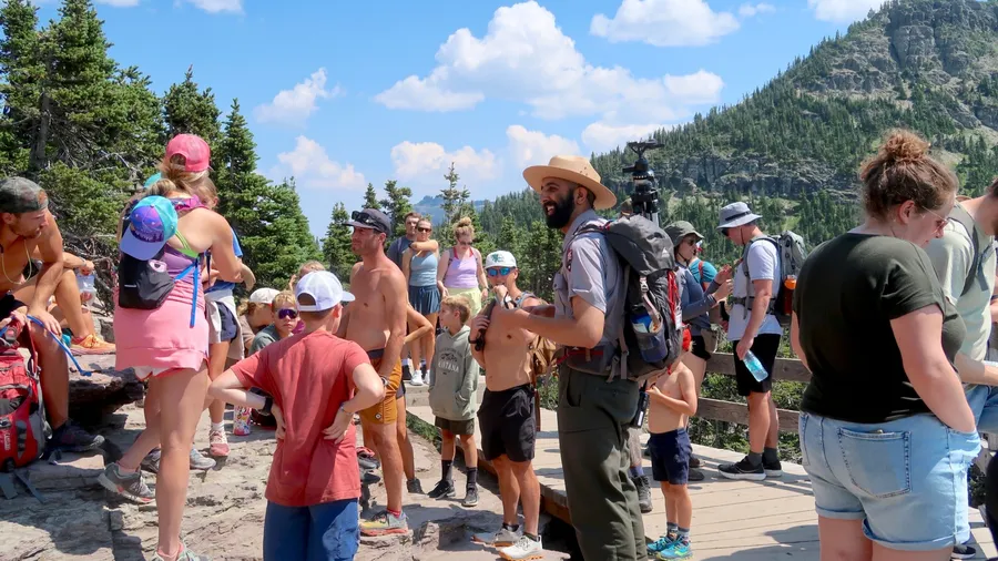 West Glacier, MT USA - July 18, 2024: A park ranger teaches about bighorn sheep and shares a horn with the people on the Hidden Lake Trailhead near Logans Pass Visitor Center
