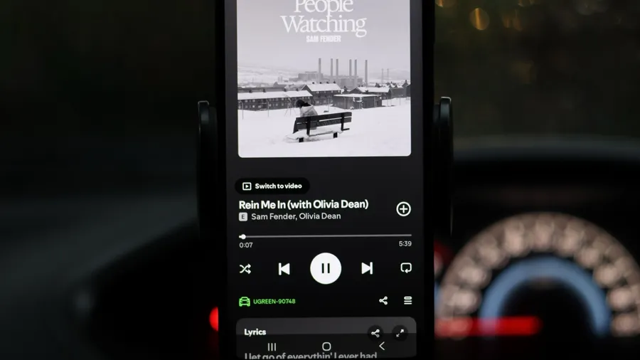 Quezon City, Philippines - Jan 10, 2026: The image displays a phone screen with a music player interface showing the song "Rein Me In" by Sam Fender featuring Olivia Dean. The track is from Fender's album People Watching.