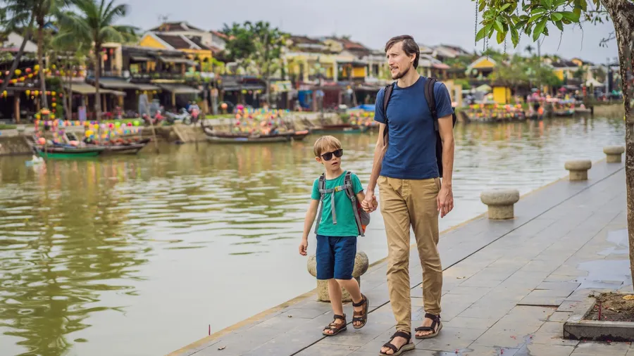 Dad and son travelers on background of Hoi An ancient town, Vietnam. Vietnam opens to tourists again after quarantine Coronovirus COVID 19