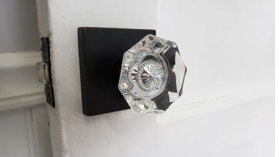 An open white door with crystal door knob.
