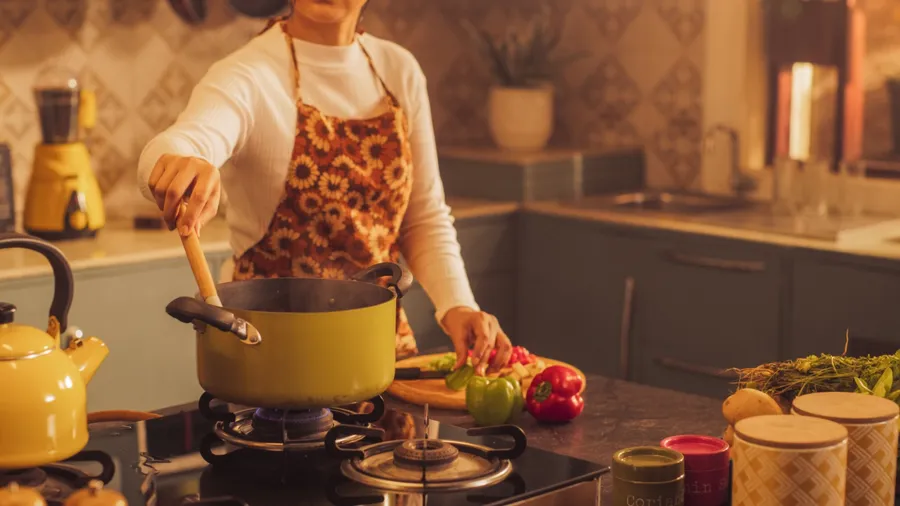 A woman cooking food in her kitchen.