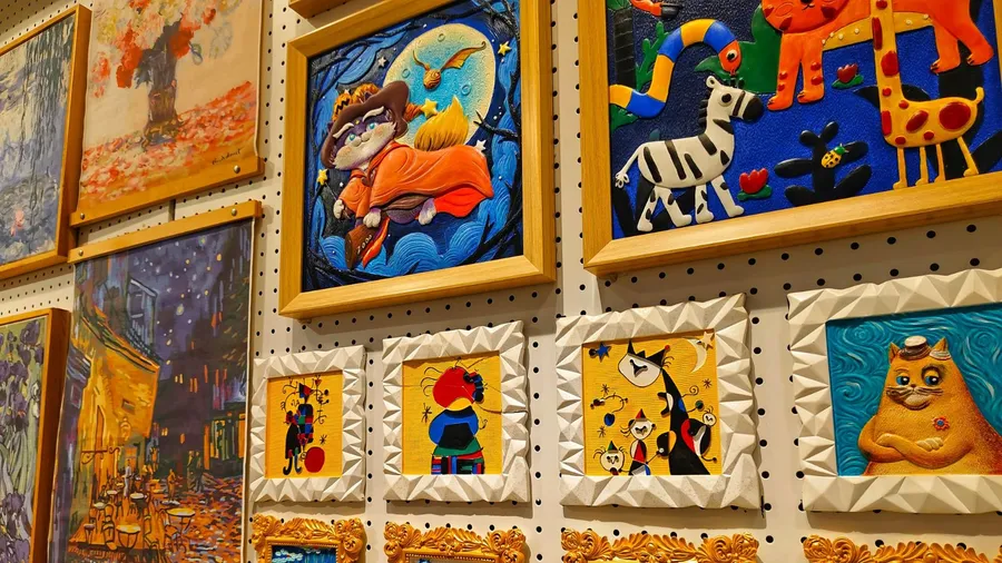 Gallery wall with colorful and artistic paintings.