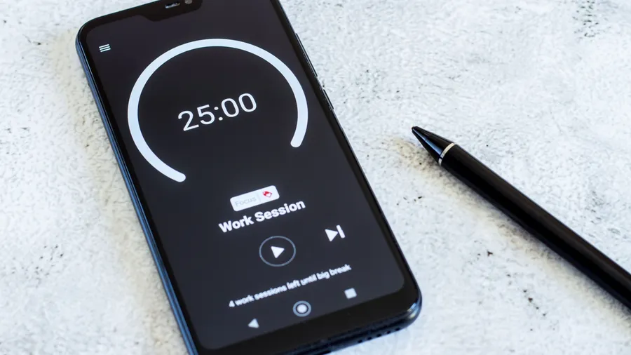 A mobile phone displaying a 25-minute timer placed on a white textured surface.