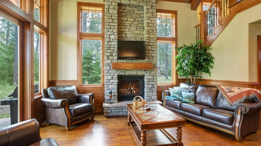 A living room interior with leather sofas, fireplace, and vintage wooden coffee table.