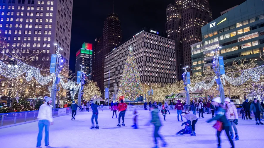 Detroit, MI, USA - December 5, 2023: Ice rink with Ice skaters with Christmas tree at Campus Martius Park at night in downtown Detroit, Michigan decorated with holiday Christmas lights