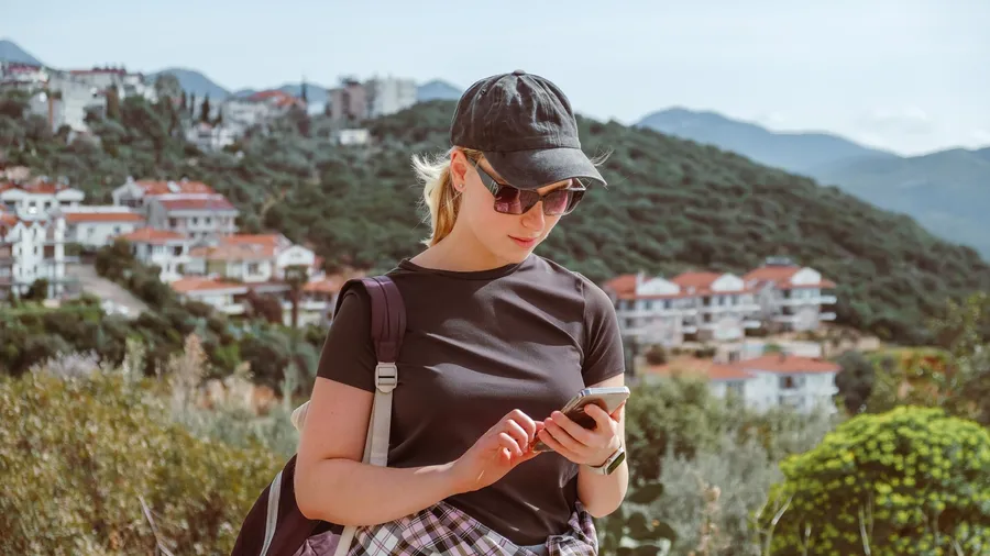 Travel,Young female traveler walking alone alongscenic mountain road solo travel, digital nomad lifestyle, eco-friendly road trip adventure.moment of mindful journeyexploration in nature.