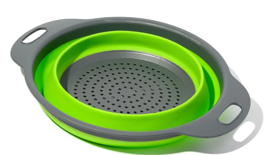 A green and gray collapsible colander against a white background.