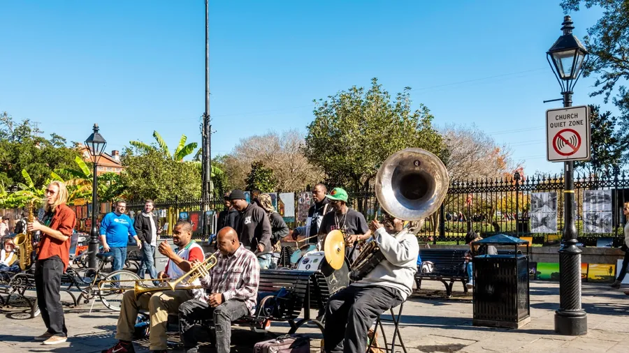 New Orleans, USA - Dec 11, 2017: A group of street musicians performing a lively jazz act to entertain the passing public. Image captured at the iconic French Quarter, in front of Jackson Square.
