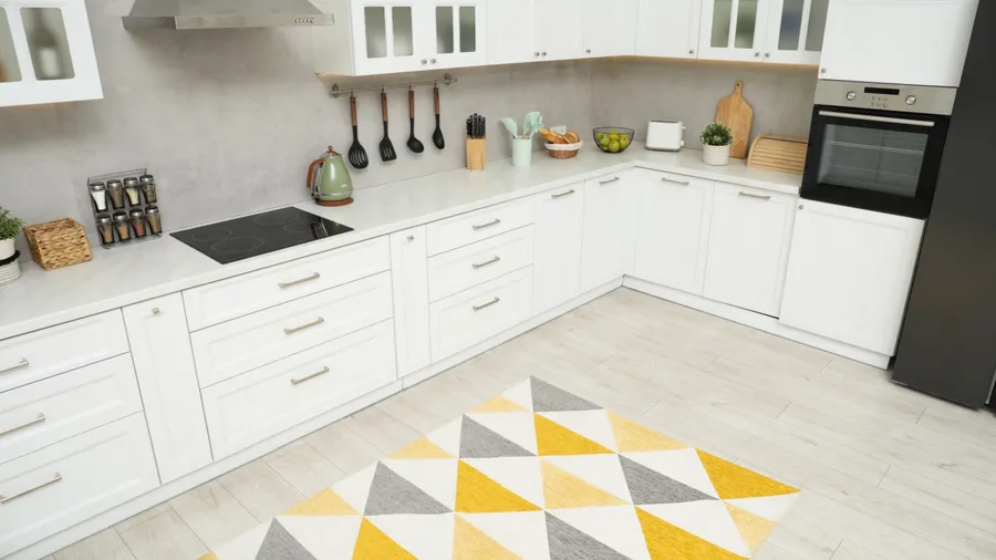 A white kitchen interior with geometric pattern rug.