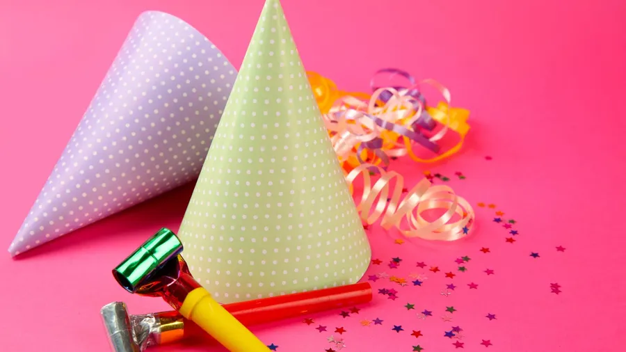 two dotted birthday hats with serpentine streamer and noise makers